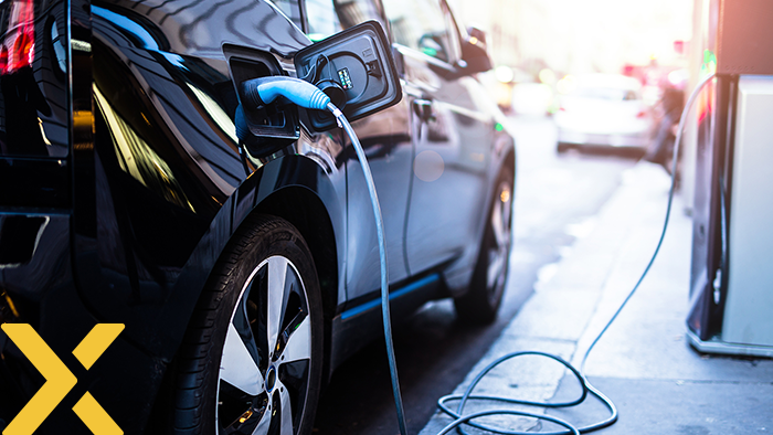 Zwarte elektrische auto die wordt opgeladen aan een laadpaal