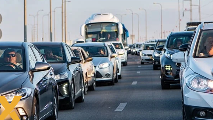 Verkeersopstopping met auto's en een touringcar op een meerbaansweg tijdens drukke spits.