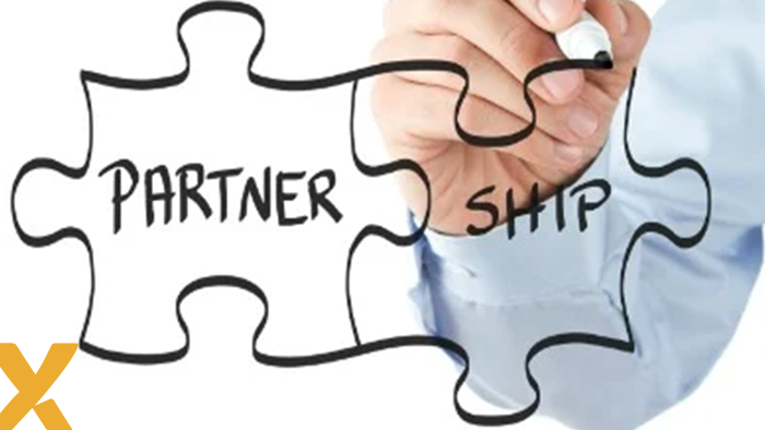 Twee in elkaar passende puzzelstukken met de tekst ‘PARTNER’ en ‘SHIP’, geschetst door een hand met een zwarte stift.