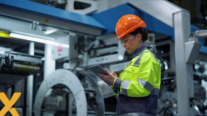 Vrouwelijke technicus met tablet inspecteert industriële installaties in een fabriek.