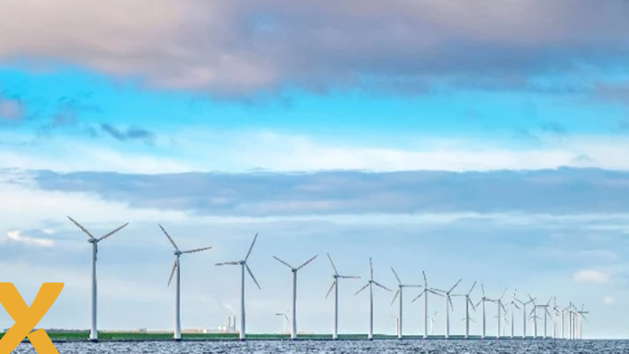 Windmolens op zee onder een bewolkte hemel, symbool voor duurzame energieopwekking.