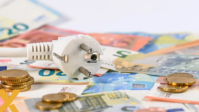 Elektriciteitsstekker op een stapel eurobiljetten en munten als symbool voor stijgende energiekosten.