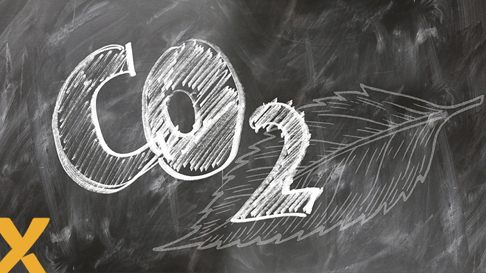 CO2-symbool getekend met krijt op een schoolbord, met een blad als achtergrond, symbool voor duurzaamheid en klimaatbewustzijn.
