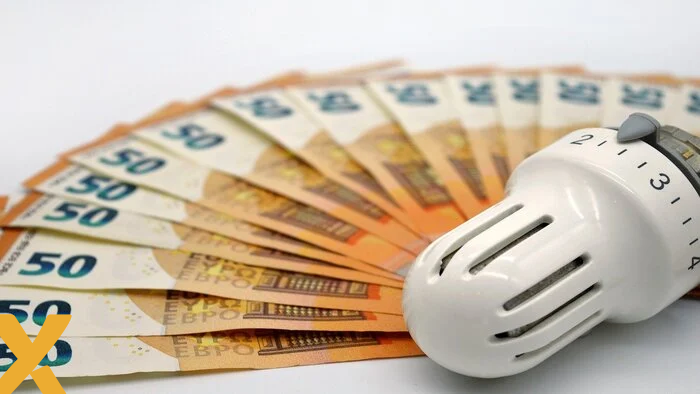 Een thermostaatknop op een waaier van vijftig eurobiljetten, symbool voor verwarmingskosten en energie-uitgaven.